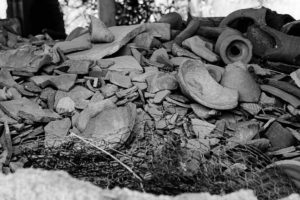 A pile of broken pottery pieces. This image is in black and white.