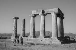 A scene of Corinth, featuring seven pillars that remain of the temple and the stairs leading into the structure. This image is in black and white.